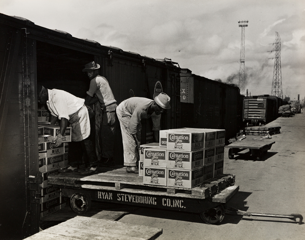 (WATERMAN STEAMSHIP CORP--SHIPPING) A group of three photographs depicting African American men unloading cargo of Carnation Milk in Mo